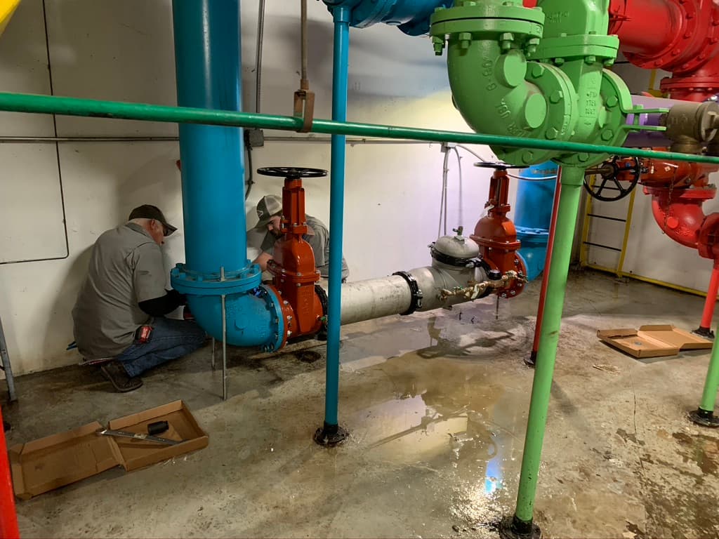 1-A Services technicians working on valves in a mechanical room